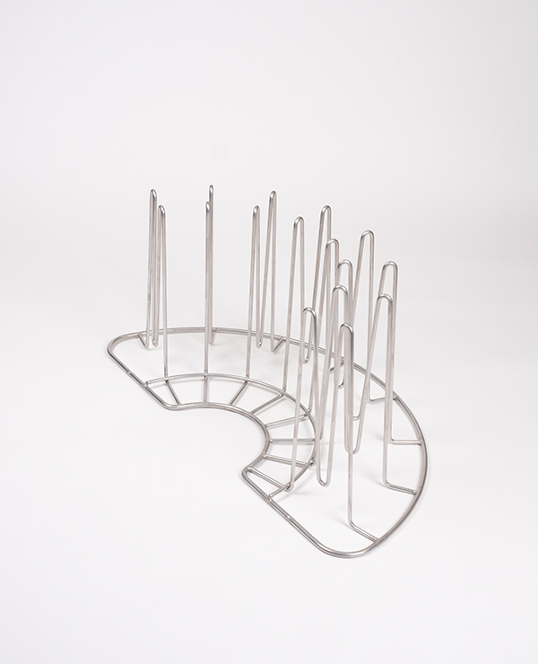 Metallhållare med vertikala piggar för dekontaminering av ansiktsmasker, stövlar och handskar i Solo Rescue-tvätten.