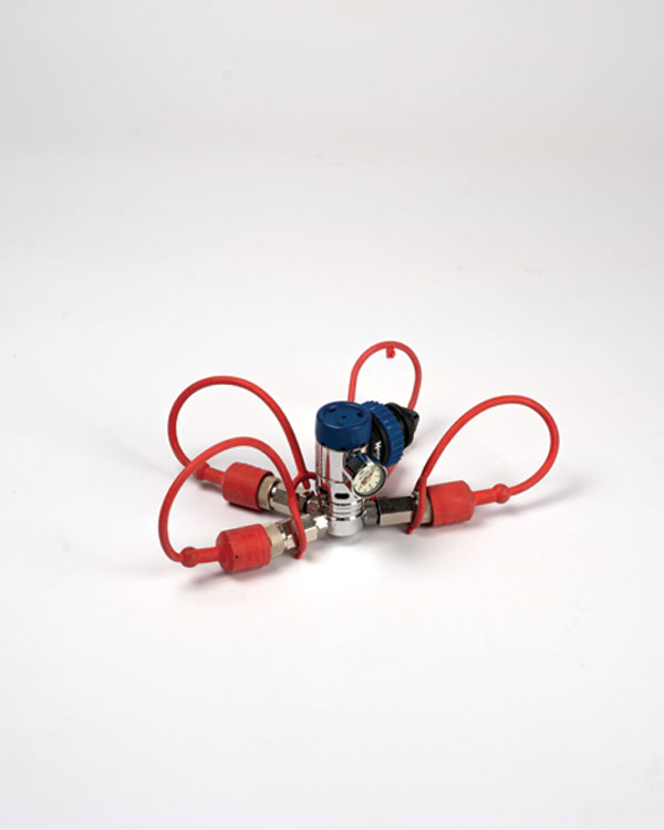 Support vide pour valves respiratoires avec tuyaux rouges, manomètre et bouchon bleu, utilisé avec un insert de pression pour un nettoyage sécurisé contre l’humidité.