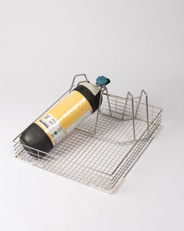 Support pour ARI et casque pour Decon Washer Pro S avec un appareil respiratoire jaune Interspiro fixé dans un rack en fil métallique.
