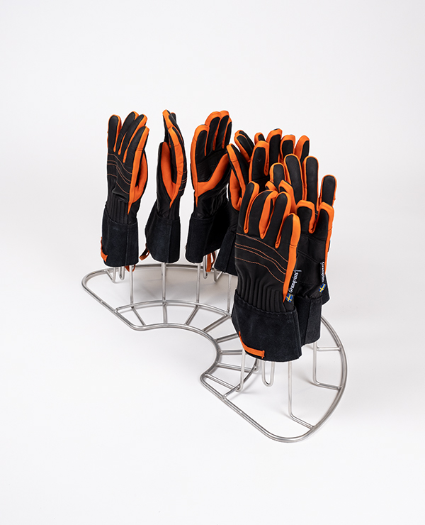 Metallhållare för utrustning med svarta och orangea handskar placerade upprätt för dekontaminering.